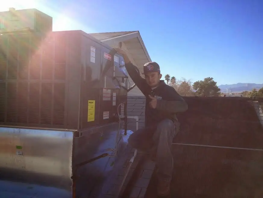 HVAC technician performing Boiler Repair on a rooftop unit in Greenville